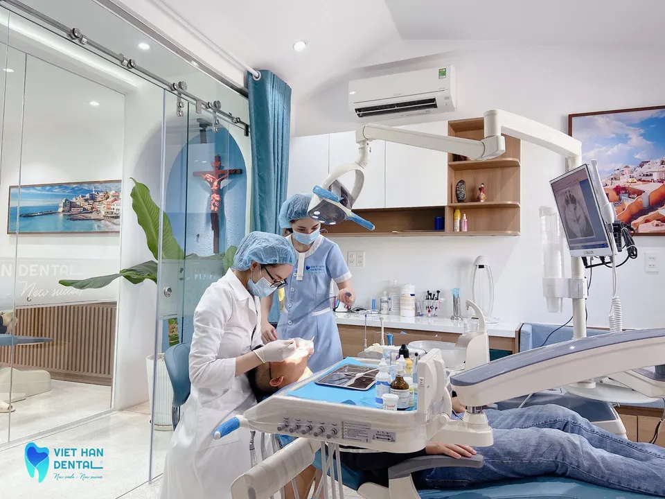 A dentist performing a routine orthodontic check-up at Viet Han Dental Clinic