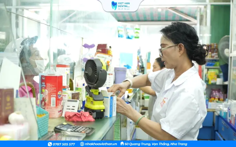 Mrs. An is standing selling medicine to customers.